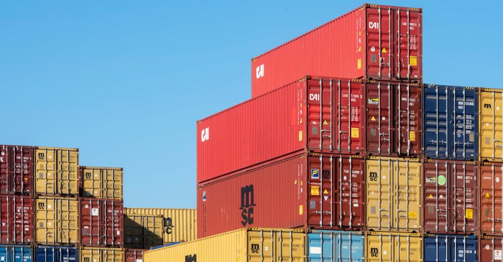 A vibrant collection of stacked shipping containers under a clear, blue sky. Ideal for logistic themes.